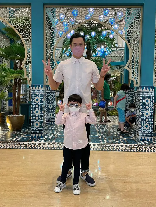 Harvey Moeis kembali tampil kembar dengan Raphael Moeis. Keduanya mengenakan atasan kemeja lengan panjang; Harvey memilih warna putih, sedangkan Raphael mengenakan warna merah muda, serta keduanya sama-sama memadukannya dengan celana panjang hitam. [Foto: Instagram/raphaelmoeis]