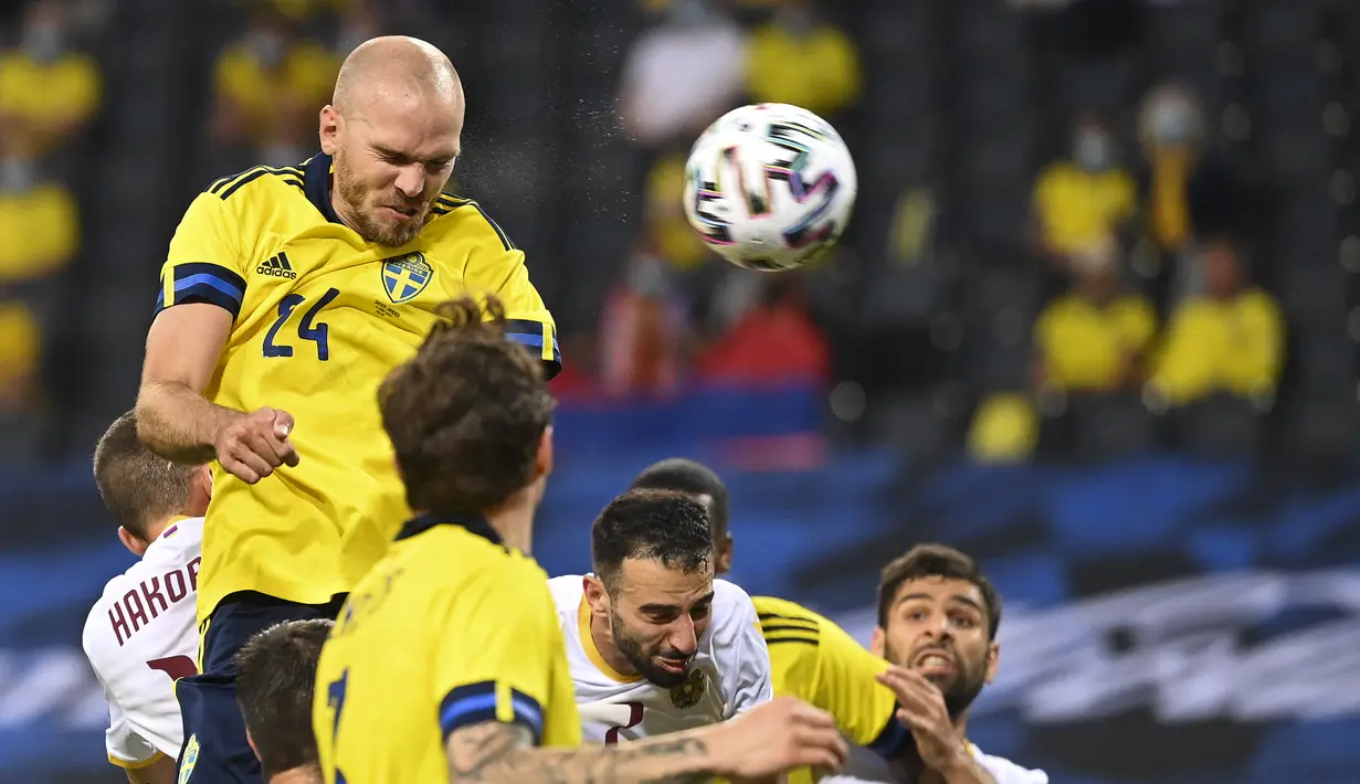 Bek Swedia, Marcus Danielson (kiri) melepaskan sundulan yang berbuah gol kedua ke gawang Armenia dalam laga uji coba menjelang berlangsungnya Euro 2020 di Solna, Sabtu (5/6/2021). Swedia menang 3-1 atas Armenia. (AFP/Jonathan Nackstrand)