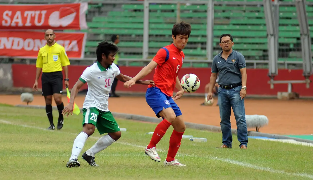 Pelatih timnas Indonesia U-23, Aji Santoso (kanan) memperhatikan duel antara Ilham Udin Armaiyn (kedua kiri) dengan Woo Jusung (Korea Selatan) di kualifikasi grup H Piala Asia 2016 di Stadion GBK Jakarta, (31/3/2015). (Liputan6.com/Helmi Fithriansyah)