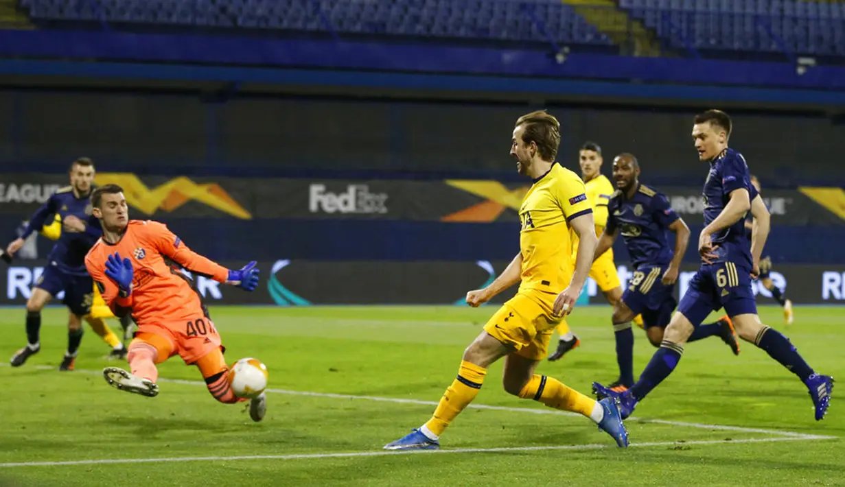Penjaga gawang Dinamo Zagreb Dominik Livakovic (kiri) melakukan penyelamatan di depan pemain Tottenham Hotspur Harry Kane pada pertandingan leg kedua babak 16 besar Liga Europa di Stadion Maksimir, Zagreb, Kroasia (18/3/2021). Tottenham kalah 0-3, sehingga agregat 2-3. (AP Photo/Darko Bandic)