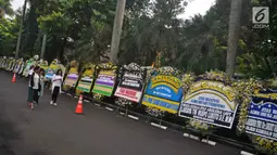 Karangan bunga ucapan bela sungkawa wafatnya Ani Yudhoyono menghiasi kawasan Puri Cikeas, Bogor, Jawa Barat, Minggu (2/6/2019). Ani Yudhoyono akan dimakamkan di samping pusara istri presiden ke-3 RI BJ Habibie, Ainun. (Liputan6.com/Immanuel Antonius)