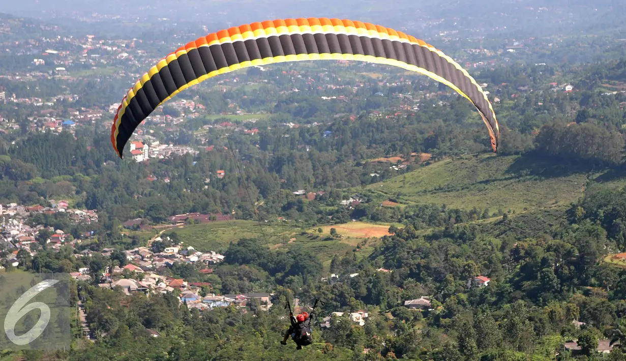 Olahraga Paralayang menjadi pilihan warga yang berkunjung ke Puncak Pass, Bogor, Jumat (6/4). Olahraga yang memacu adrenalin ini dipatok dengan harga Rp. 350 Ribu. (Liputan6.com/Johan Tallo)