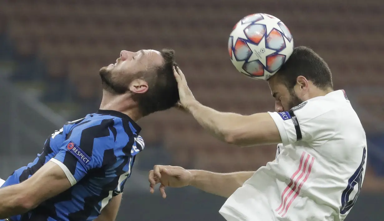 Bek Real Madrid, Nacho, berebut bola dengan bek Inter Milan, Stefan de Vrij, pada laga lanjutan Liga Champions di Giuseppe Meazza, Kamis (26/11/2020) dini hari WIB. Real Madrid menang 2-0 atas Inter Milan. (AP Photo/Luca Bruno)