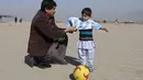 Bocah 5 tahun, Murtaza Ahmadi, asal Afghanistan menerima jersey  asli Lionel Messi lengkap dengan tanda tangan, sebelumnya bocah ini mengenakan jersey plastik nomor 10 dengan tulisan Lionel Messi. (REUTERS/Omar Sobhani)