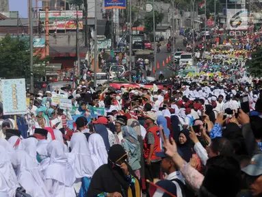 Ribuan warga menyaksikan pawai Musabaqah Tilawatil Quran (MTQ) ke-9 tingkat Kota Tangerang Selatan (Tangsel), Banten, Senin (17/9). Pawai dilakukan di sepanjang Jalan Siliwangi, Pamulang. (Merdeka.com/Arie Basuki)