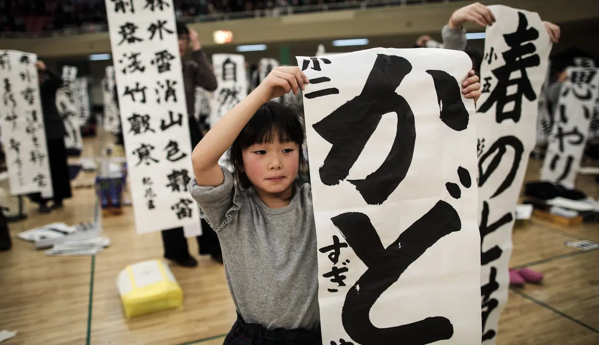 Peserta menunjukkan tulisan Jepang mereka saat mengikuti lomba kaligrafi Tokyo, Jepang (5/1). Lomba kaligrafi tulisan Jepang ini digelar setiap tahun yang diadakan pada awal tahun baru. (AFP Photo/Behrouz Mehri)