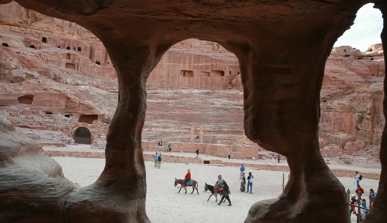 Wisatawan menaiki keledai saat mengunjungi kota arkeologi Petra, Yordania, Kamis (21/11/2019). Bangunan Petra sangat memukai dengan perpaduan gaya Timur dan Helenistik. (AHMAD ABDO/AFP)