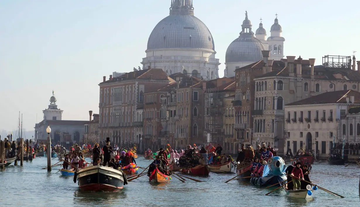 <p>Suasana kemeriahan Karnaval Venesia saat perahu-perahu berlayar dalam parade dayung tradisional. (AP Photo/Luca Bruno)</p>