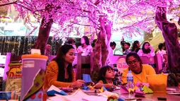 Anak-anak sedang belajar menggambar di bawah pohon sakura Mal Taman Anggrek, Jakarta (02/04). Area bermain dan belajar yang mirip di Jepang ini juga menghadirkan beragam flora dan fauna. (Liputan6.com/Fery Pradolo)