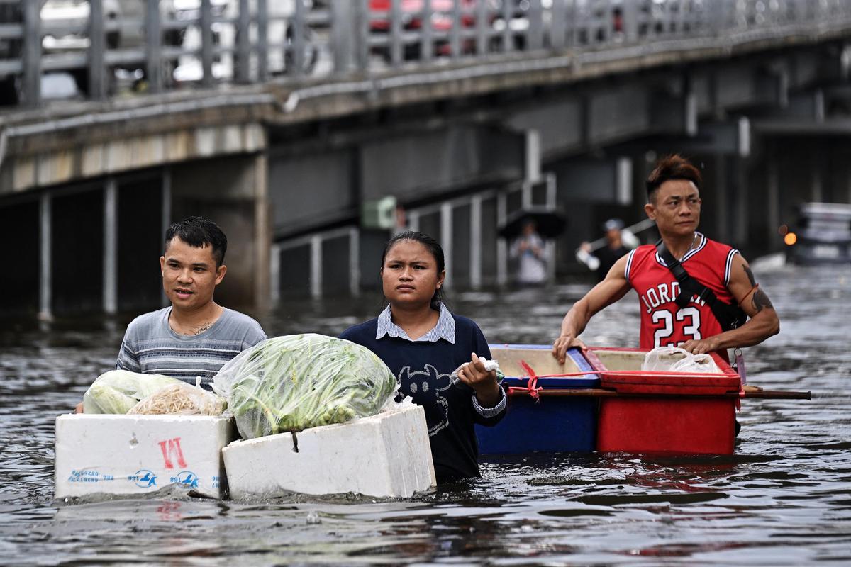 Banjir Parah Rendam Bangkok Warga Berjualan di Tengah Genangan