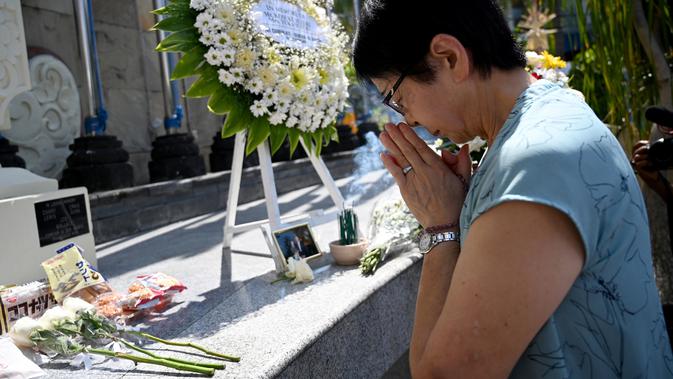 Seorang wanita asal Jepang berdoa di Monumen Bom Bali, Kuta, dekat Denpasar pada Sabtu (12/10/2019). MeMperingati 18 tahun peristiwa bom Bali yang terjadi pada 12 Oktober 2002, wisatawan dan kerabat korban mengunjungi tugu peringatan untuk berdoa dan tabur bunga. (SONNY TUMBELAKA / AFP)