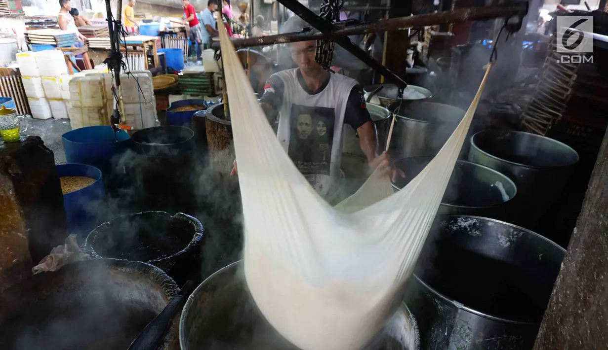 Pekerja tengah mengolah untuk pembuatan tahu di industri rumahan di Jakarta, Senin (22/1). Turunnya KUR ini bertujuan untuk menyasar sektor produktif seperti manufaktur, agribisnis maupun pertanian. (Liputan6.com/Angga Yuniar)