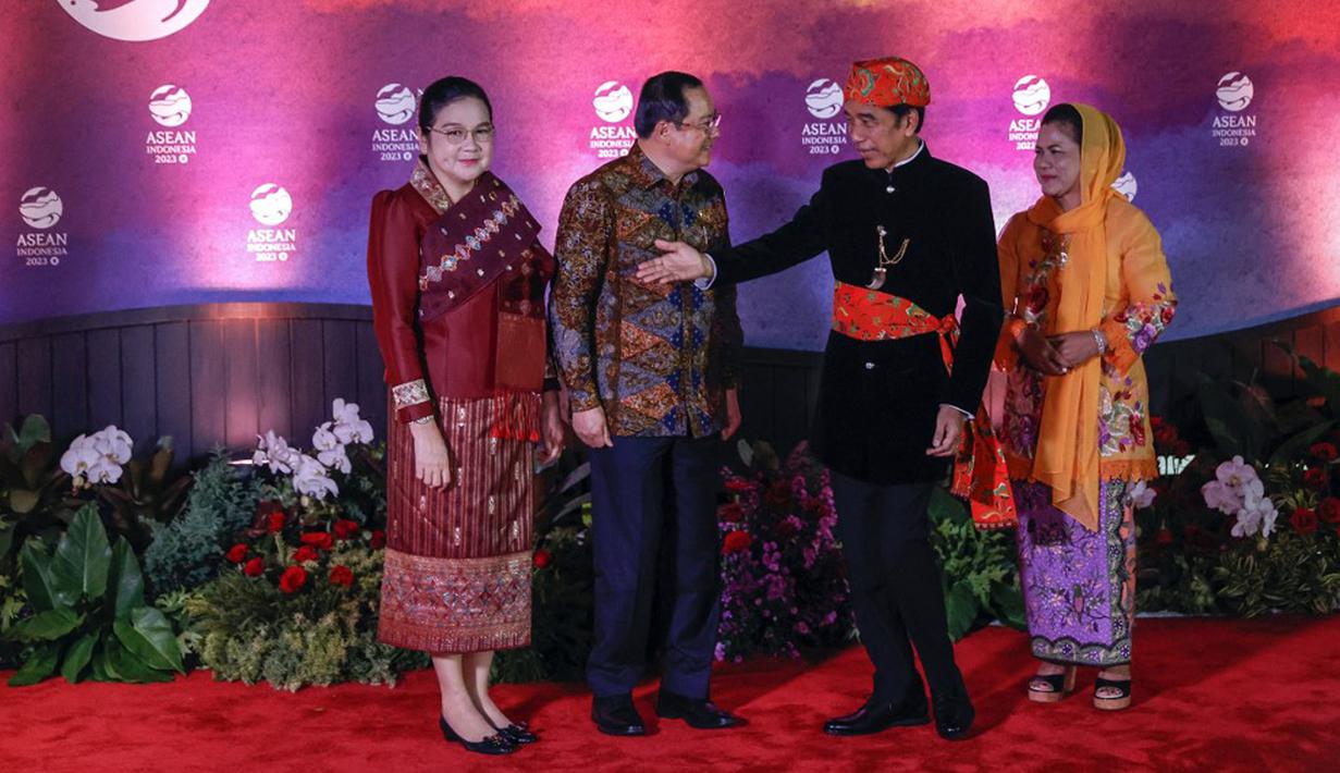 Perdana Menteri Laos Sonexay Siphandone (kedua kiri) dan istrinya Vandara Siphandone (kiri) disambut oleh Presiden Indonesia Joko Widodo atau Jokowi (kedua kanan) dan Ibu Negara Iriana Widodo pada gala dinner KTT ke-43 ASEAN di Jakarta, Indonesia, Rabu (6/9/2023). (Mast IRHAM/POOL/AFP)