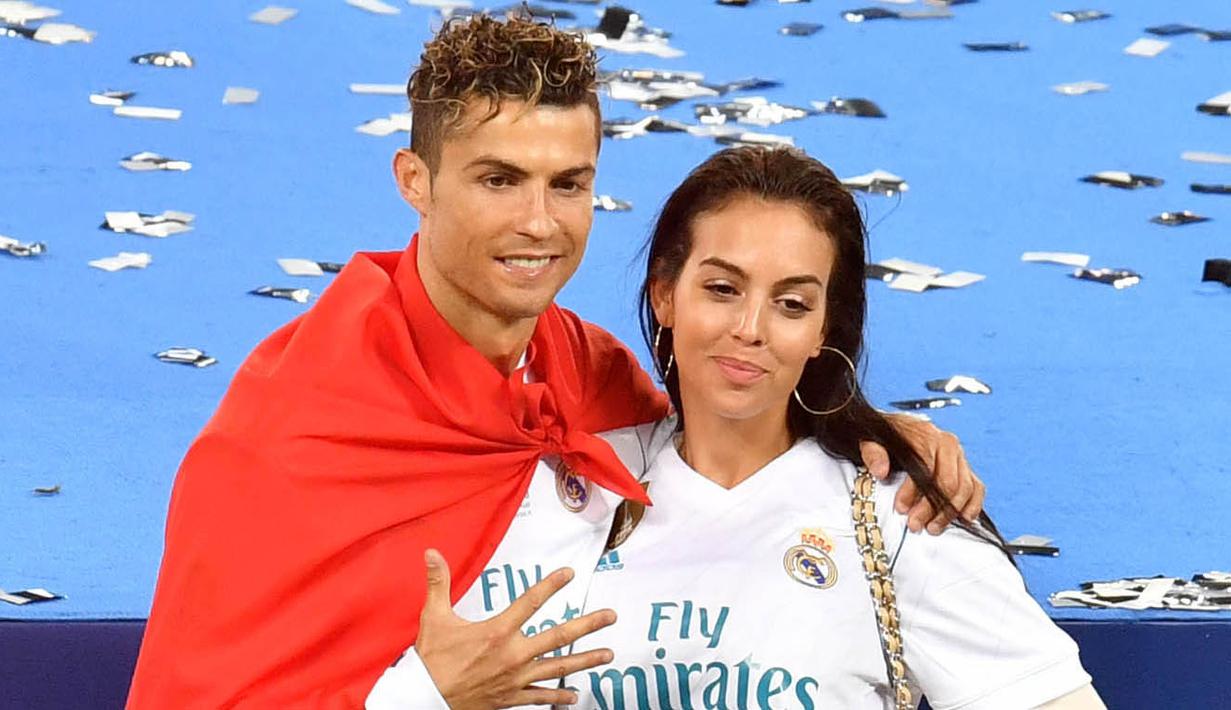 Cristiano Ronaldo bersama kekasihnya, Georgina Rodriguez, berpose usai menjuarai Liga Champions bersama Real Madrid di Stadion Olympic, Kiev (19/5/2019). (AFP/Sergei Supinsky)