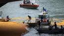 Para relawan mengumpulkan bebek karet yang dilemparkan ke sungai Chicago, pusat kota Chicago, Kamis (9/8). Lebih dari 50.000 bebek karet dilombakan di Sungai Chicago sebagai bagian dari acara amal Windy City Rubber Ducky Derby. (AP Photo/Annie Rice)