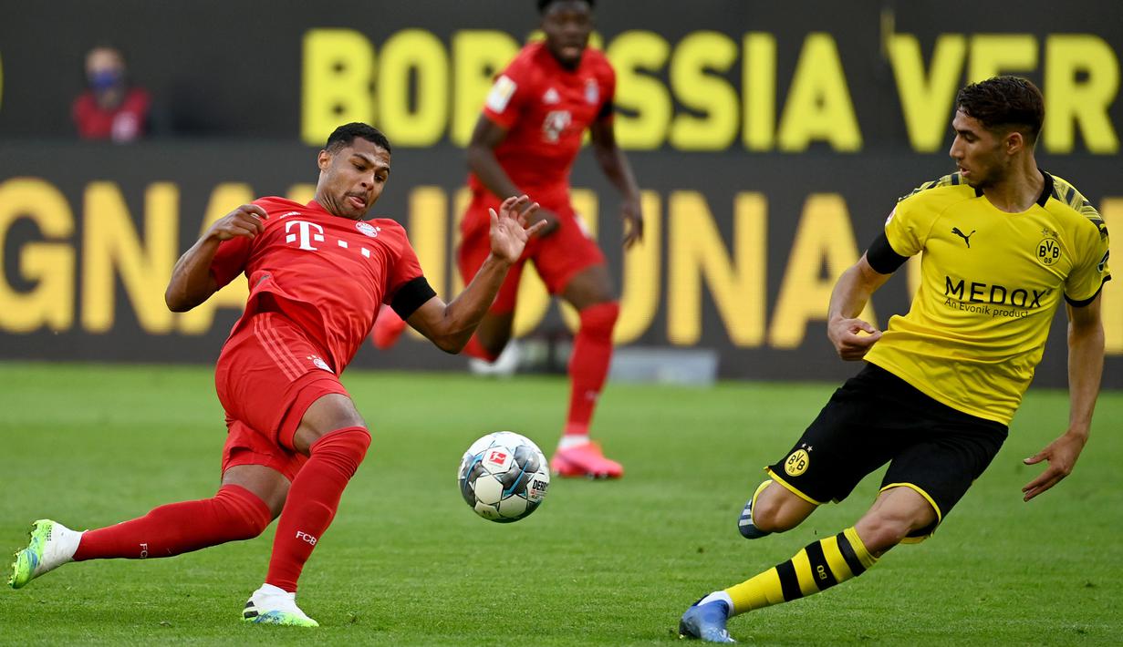 Gelandang Bayern Munchen, Serge Gnabry, berebut bola dengan bek Borussia Dortmund, Achraf Hakimi, pada laga pekan ke-28 Bundesliga di Stadion Signal Iduna Park, Selasa (26/5/2020) waktu setempat. Bayern Munchen menang 1-0 atas Borussia Dortmund. (AFP/Federico Gambarini/Pool)