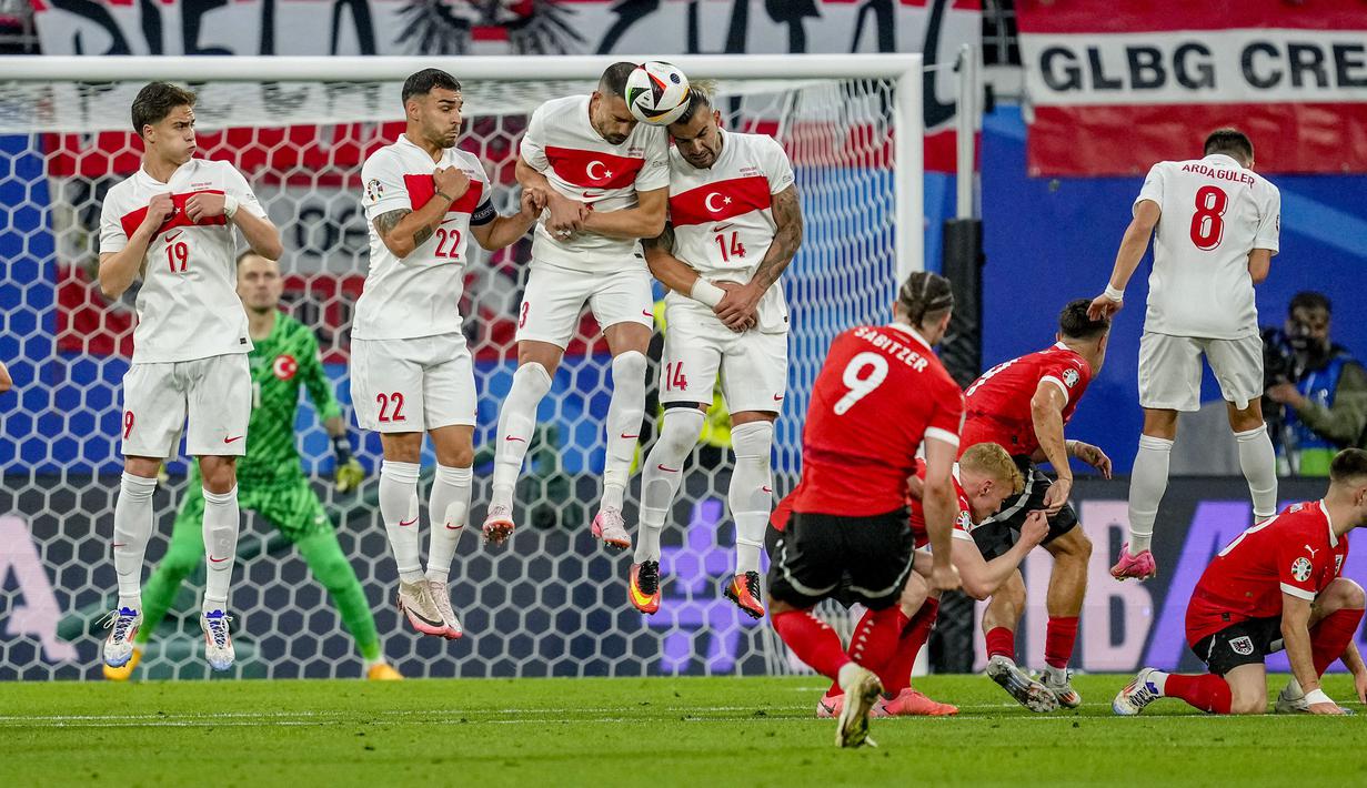 Para pemain Timnas Turki berusaha memblok eksekusi tendangan bebas gelandang Timnas Austria, Marcel Sabitzer pada laga babak 16 besar Euro 2024 di Red Bull Arena, Leipzig, Jerman, Rabu (3/7/2024). (AP Photo/Darko Vojinovic)