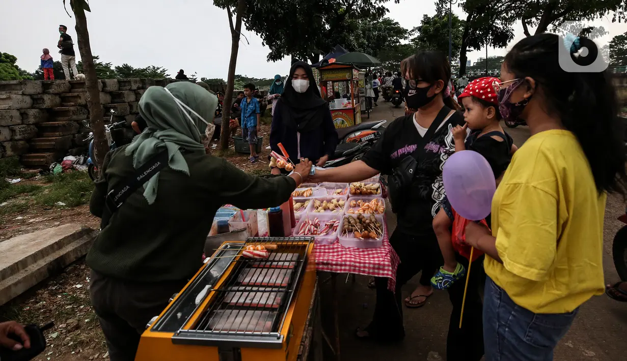 Warga membeli hidangan untuk berbuka puasa di ruang kota Jalan Inpeksi Tanah Kusir, Jakarta, Senin (19/4/2021). Jalan Inpeksi Tanah Kusir ini menjadi salah satu tempat pilihan warga untuk menghabiskan waktu sembari menunggu berbuka puasa atau ngabuburit. (Liputan6.com/Johan Tallo)