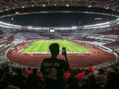 Seorang pendukung Persija Jakarta mengabadikan momen menggunakan gawainya sebelum laga terakhir BRI Liga 1 2022/2023 antara Persija Jakarta melawan PSS Sleman di Stadion Utama Gelora Bung Karno (SUGBK), Senayan, Jakarta, Sabtu (15/04/2023). (Bola.com/Bagaskara Lazuardi)