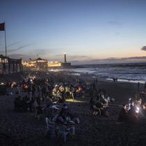 Orang-orang berbuka puasa di tepi pantai di Rabat, Maroko, Sabtu (23/4/2022). Untuk pertama kalinya dalam dua tahun sejak pandemi COVID-19, orang-orang dapat menghidupkan kembali tradisi Ramadhan dengan berkumpul dan berbuka puasa di tempat umum. (AP Photo/Mosa'ab Elshamy)