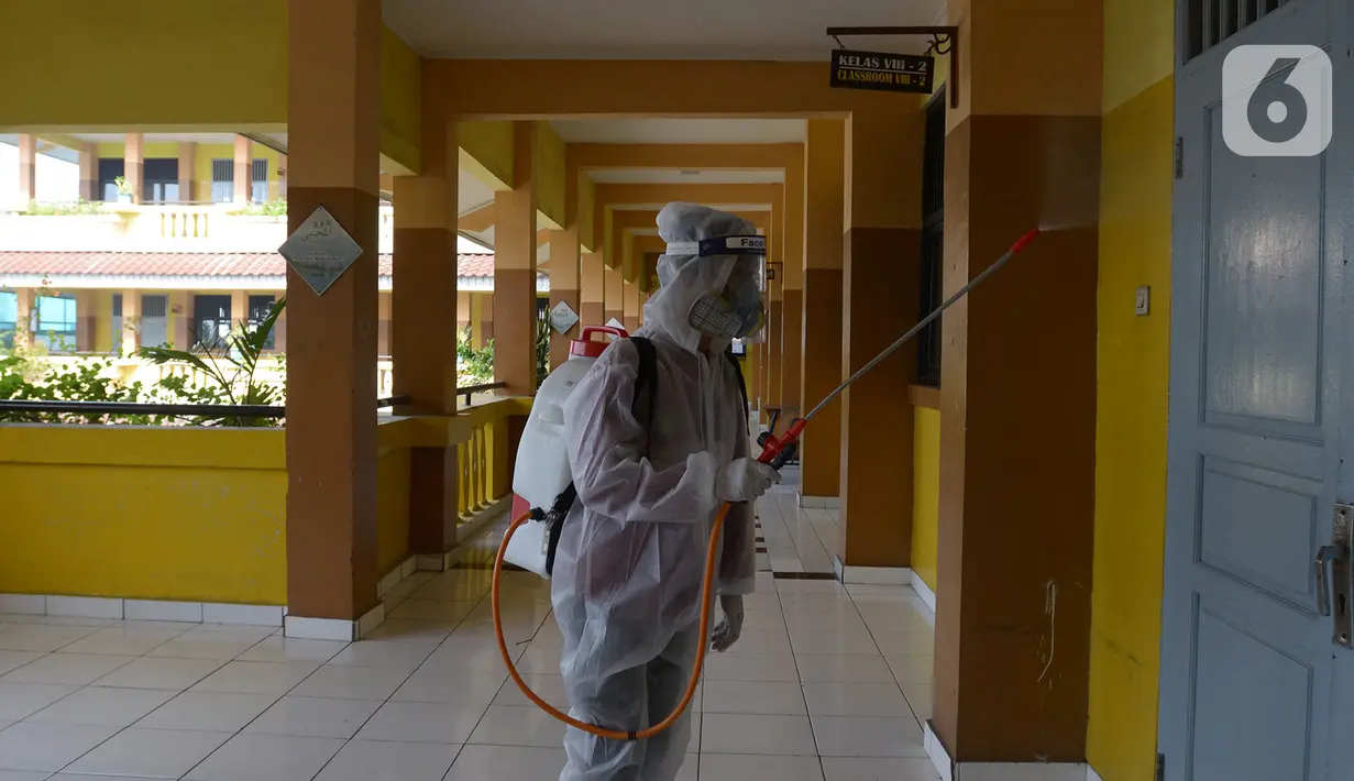 Petugas PMI menyemprotkan cairan disinfektan di Lingkungan SMP Negeri 139 Jakarta, Selasa (9/6/2020). Penyemprotan untuk mencegah penyebaran virus Corona di lingkungan sekolah itu sebagai persiapan memasuki tahun ajaran baru 2020/2021. (merdeka.com/Imam Buhori)