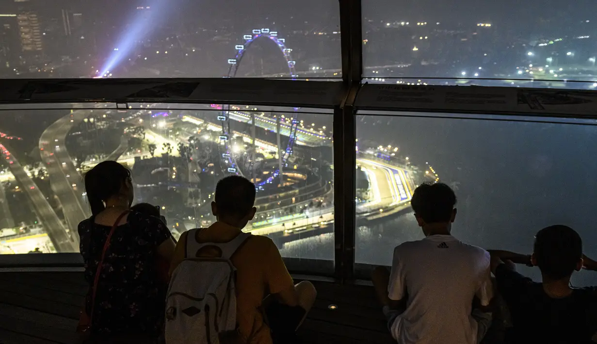 Turis melihat Sirkuit Marina Bay Street yang diselimuti kabut asap di Singapura (18/9/2019). Balapan di sirkuit ini dianggap sebagai salah satu balapan F1 paling menguras fisik karena iklim Singapura yang lembab.(AFP Photo/Roslan Rahman)