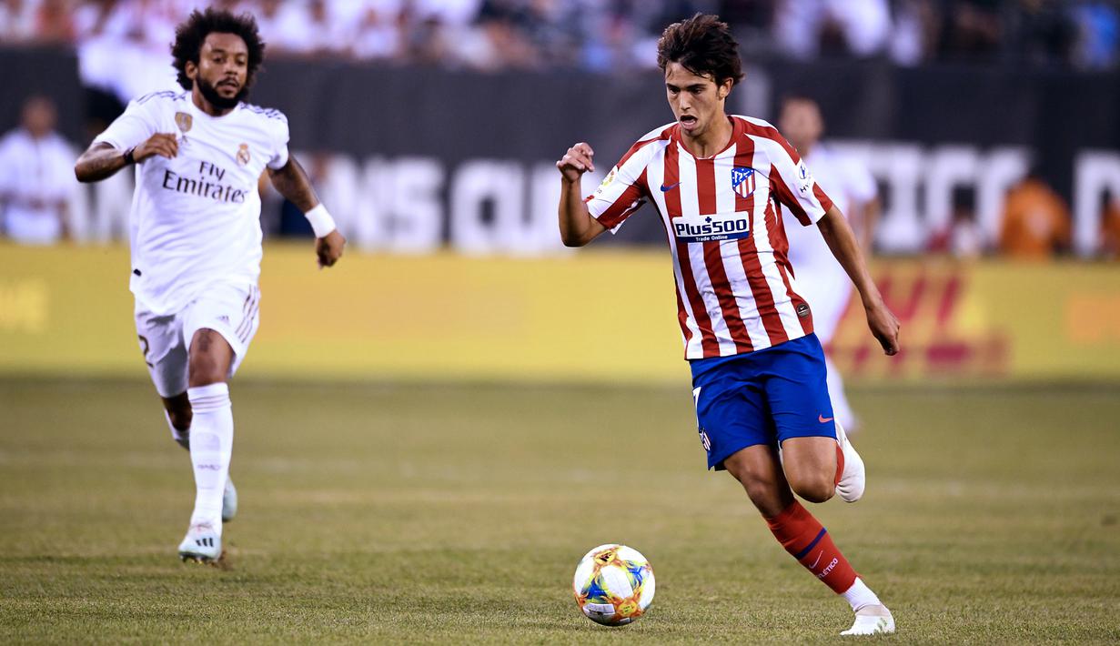 Gelandang Atletico Madrid, Joao Felix menggiring bola dari kejaran bek Real Madrid, Marcelo selama laga International Champions Cup 2019 di Arena Stadium Metlife, New Jersey (27/7/2019). (AFP Photo/Johannes Eisele)