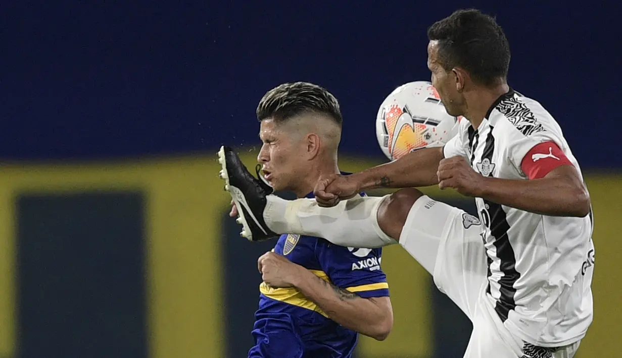 Gelandang Boca Juniors, Jorman Campuzano, berebut bola dengan gelandang Libertad, Sergio Aquino, pada laga grup H Copa Libertadores di Estadio La Bombonera, Rabu (30/9/2020) dini hari WIB. Boca Juniors bermain imbang 0-0 atas Libertad. (Juan Mabromata/Pool via AP)