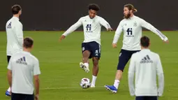 Pemain Spanyol, Adama Traore, berebut bola dengan Sergio Ramos saat sesi latihan jelang menghadapi Jerman pada laga lanjutan Grup 4 UEFA Nations League di Stadion De La Cartuja, Selasa (17/11/2020). Spanyol akan berhadapan dengan Jerman. (AFP/Cristina Quicler)