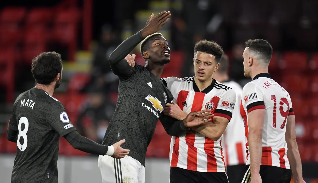 Gelandang Manchester United, Paul Pogba (kedua dari kiri), terlibat pertikaian dengan bek Sheffield United, Jack Robinson (kanan), dalam laga lanjutan Liga Inggris 2020/21 pekan ke-13 di Bramall Lane, Sheffield, Kamis (17/12/2020). Manchester United menang 3-2 . (AFP/Peter Powell).