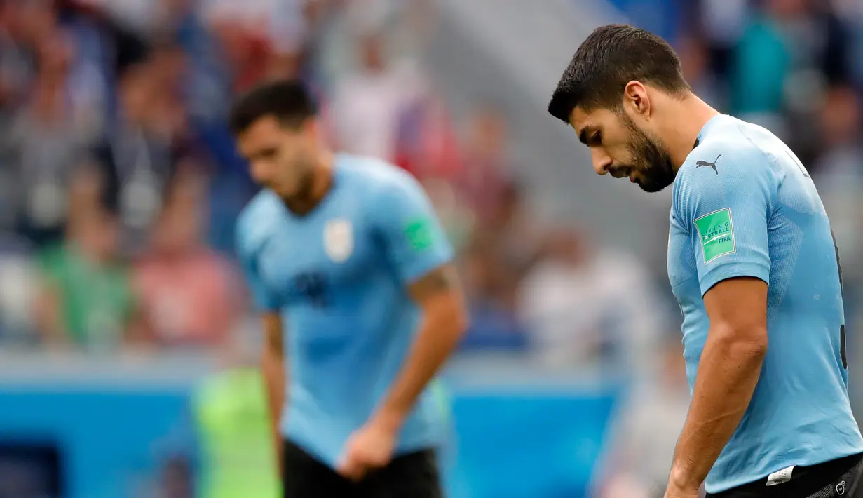 Kesedihan pemain Uruguay, Luis Suarez dan Maximiliano Gomez saat meninggalkan lapangan setelah kalah atas Prancis pada perempat final Piala Dunia 2018 di Nizhny Novgorod Stadium, Jumat (6/7). Uruguay ditumbangkan Prancis dengan skor 0-2. (AP/Hassan Ammar)