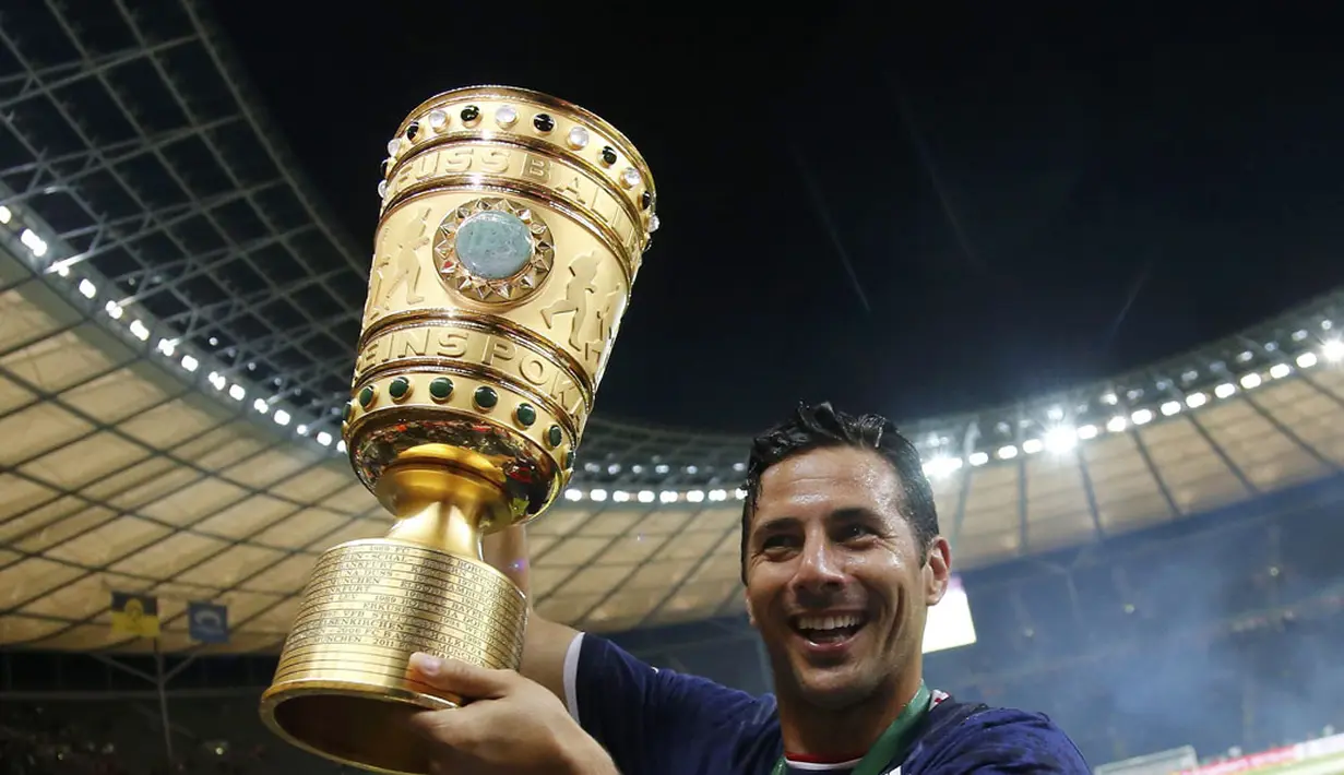 Pemain Bayern München, Claudio Pizarro mengangkat trofi DFB Pokal usai membungkam Borussia Dortmund 2-0 di Olympiastadion, Berlin (18/5/2014). (REUTERS/Tobias Schwarz)