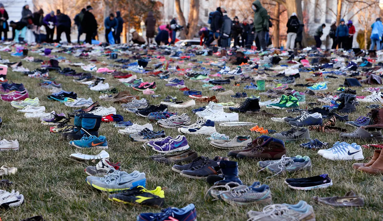 Ribuan sepatu menutupi halaman rumput di depan Gedung Capitol, Washington DC, Selasa (13/3). Sekitar 7000 ribu sepatu hasil sumbangan warga dan aktivis ini melambangkan korban penembakan di bawah usia 18 tahun. (Paul Morigi/AP Images for AVAAZ)