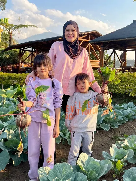 Tidak hanya menikmati serunya jalan-jalan dengan menikmati pemandangan alam. Ryana Dea juga mengajak kedua buah hatinya mengunjungi kebun untuk memetik buah bit dan tomat secara langsung. Wisata seperti ini tentu bikin anak-anak antusias, apalagi biasanya tinggal di kota besar. (Liputan6.com/IG/@ryana_dea)