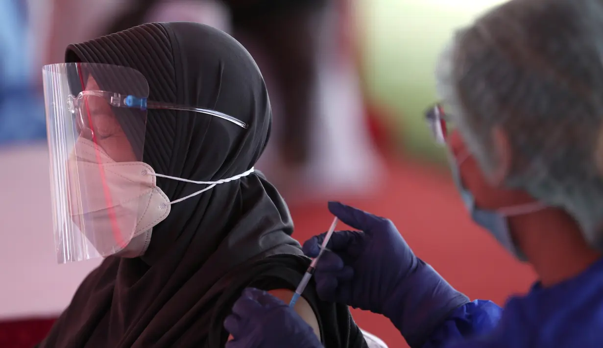 Seorang wanita menerima suntikan vaksin Sinovac saat vaksinasi massal virus corona COVID-19 untuk umum di Patriot Candrabhaga Sadium, Bekasi, Jawa Barat, Senin (14/6/2021). Peminat vaksinasi COVID-19 di Stadion Patriot Candrabagha sangat tinggi. (AP Photo/Achmad Ibrahim)