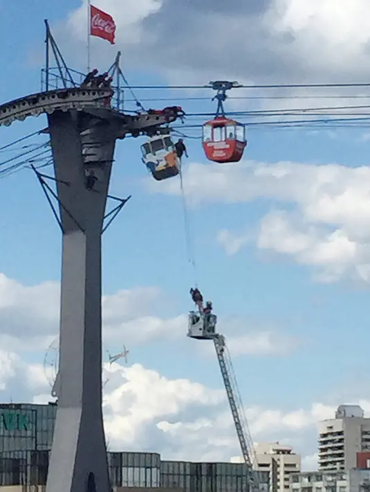 Tim pemadam kebakaran mengevakuasi penumpang kereta gantung yang terjebak di udara di Kota Koln, Jerman, Minggu (30/7). 32 kereta gantung mendadak terhenti usai menabrak tiang penyangga hingga membuat penumpangnya terjebak. (Martin Oversohl/dpa via AP)