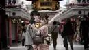 Pengunjung dengan masker pelindung untuk membantu mencegah penyebaran virus corona berfoto selfie di pusat perbelanjaan di distrik Asakusa di Tokyo, Selasa (29/9/2020). kota Jepang mengonfirmasi lebih dari 200 kasus virus corona pada hari Selasa. (AP Photo/Eugene Hoshiko)