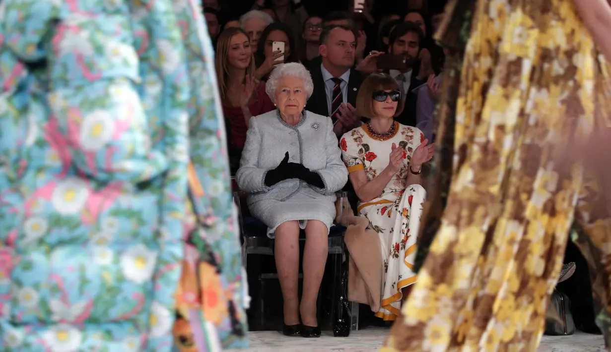 Ratu Elizabeth II duduk di sebelah Ratu Fashion, Anna Wintour menyaksikan pagelaran London Fashion Week 2018, Selasa (20/2). Ratu Elizabeth tampil stylish mengenakan setelan jaket dan rok biru muda keluaran Angela Kelly. (Yui Mok/Pool photo via AP)