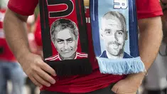 Seorang fans mengenakan slayer bergambar pelatih Manchester City,  Pep Guardiola (kanan) dan pelatih  Manchester United, Jose Mourinho,  pada laga Premier League di Old Trafford, Manchester,  (10/9/2016). (AFP/Oli Scarff)