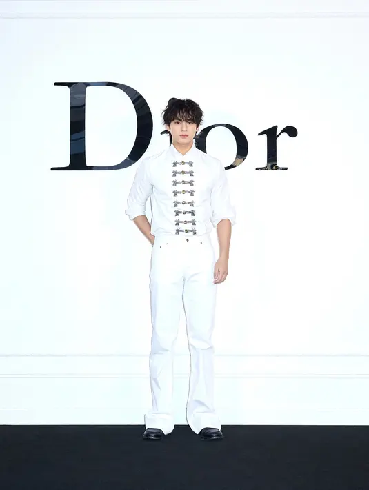 Mingyu tampil memikat bak pangeran dengan tampilan all white. Memadukan kemeja putih beraksen pita yang charming dan celana yang serasi. [Dior]
