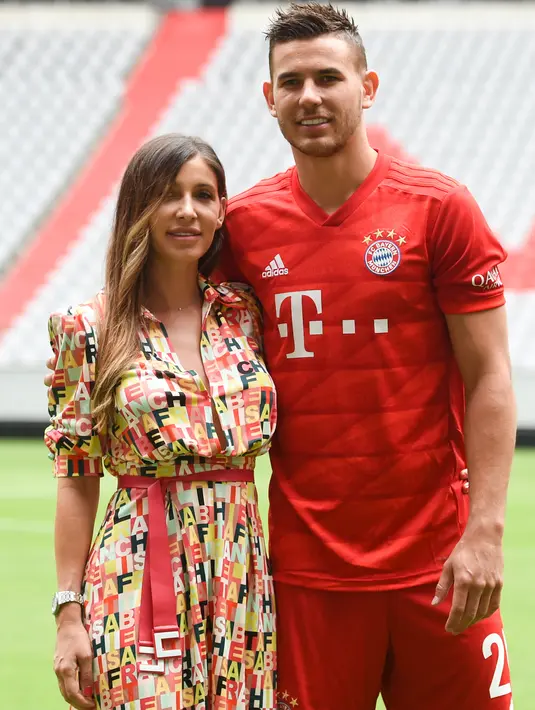 Bek baru Bayern Munchen, Lucas Hernandez berpose bersama istrinya, Amelia Lorente saat diperkenalkan secara resmi di Allianz Arena, Senin (8/7/2019). Lucas Hernandez menjadi bek termahal di dunia setelah diboyong Bayern Munchen dari Atletico Madrid dengan harga 80 juta euro. (Christof STACHE/AFP)