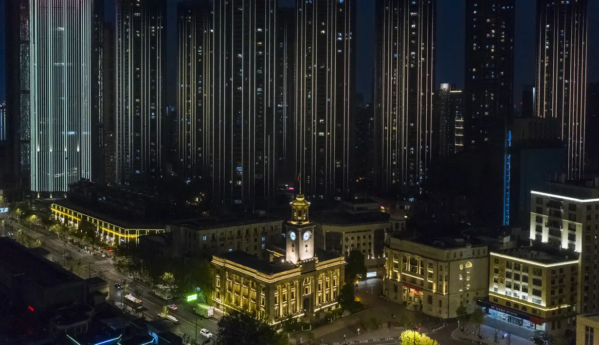 Sejumlah bangunan berselimut cahaya lampu di Wuhan, Provinsi Hubei, China, 7 April 2020. Wuhan mencabut larangan perjalanan keluar mulai 8 April 2020 setelah penerapan karantina wilayah (lockdown) selama hampir 11 pekan untuk membatasi penyebaran virus corona COVID-19. (Xinhua/Shen Bohan)