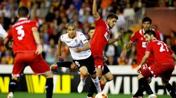 Gelandang Valencia, Sofiane Feghouli mencoba lolos dari kepungan pemain Sevilla saat berlaga di semifinal kedua Liga Europa di Stadion Mestalla, Valencia (2/5/2014). (REUTERS/Heino Kalis)  