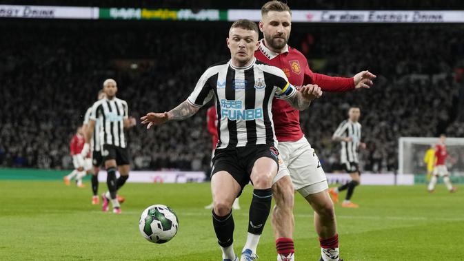 Bek Manchester United (MU) Luke Shaw berebut bola dengan bek Newcastle United Kieran Trippier pada partai final Carabao Cup 2022/2023 di Stadion Wembley, Senin dini hari WIB (27/2/2023). MU tampil tangguh untuk membekuk Newcastle dengan skor meyakinkan 2-0 dan menjadi juara Carabao Cup 2022-2023. (AP Photo/Alastair Grant)