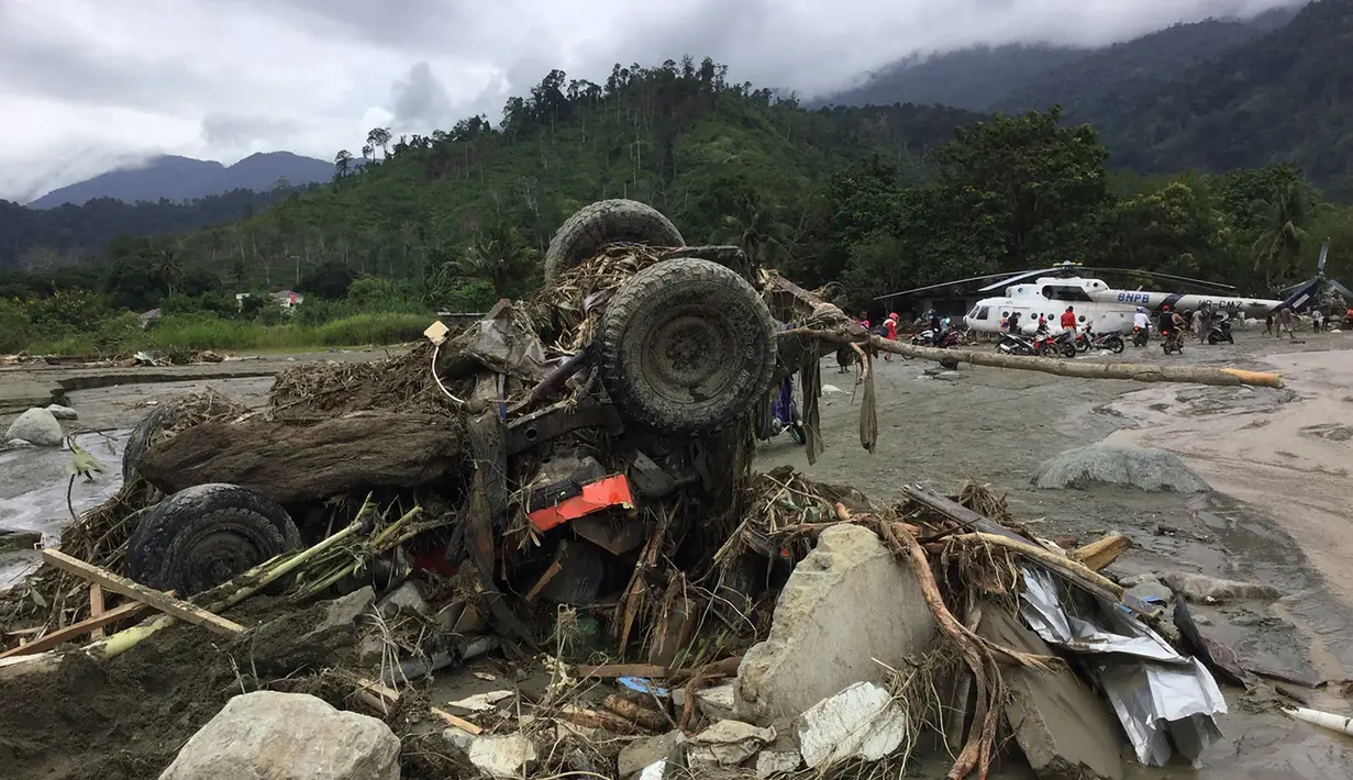 Sebuah kendaraan yang hanyut dengan puing-puing tersapu banjir bandang di Kabupaten Sentani, Jayapura, (17/3). Banjir bandang Sentani menewaskan 70 orang dan puluhan luka-luka. (AFP/Netty Dharma Somba)