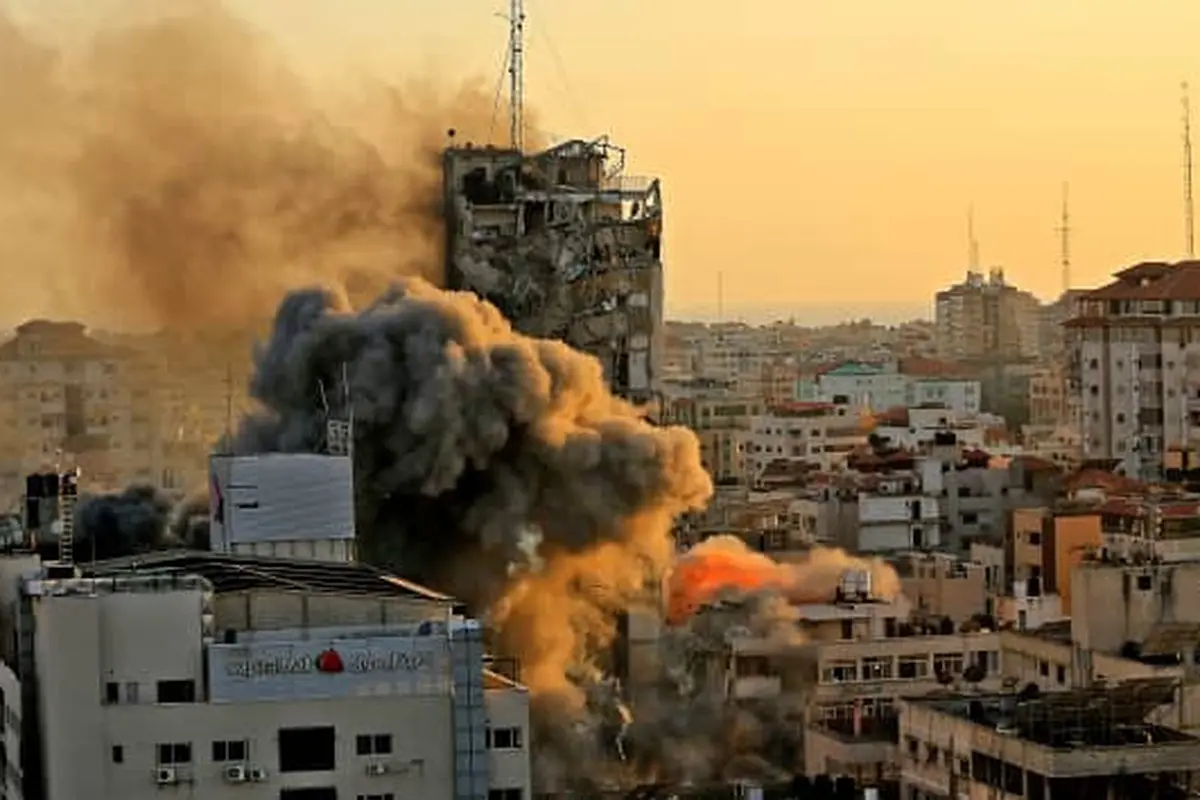 Asap tebal dan api naik dari menara Al-Sharouk saat runtuh setelah terkena serangan udara Israel, di Kota Gaza, pada 12 Mei 2021. QUSAY DAWUD | AFP