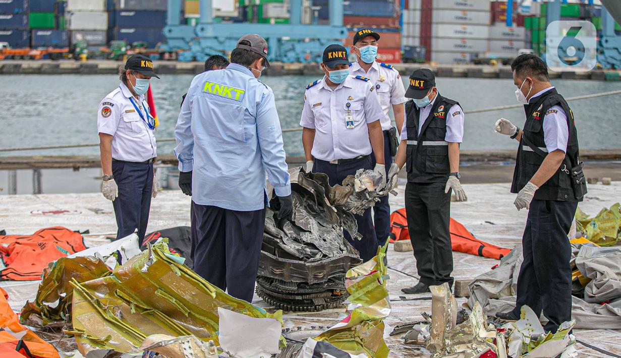 Petugas KNKT memeriksa bagian turbin pesawat Sriwijaya Air dihari kelima yang jatuh di perairan Pulau Seribu, di Dermaga JICT, Jakarta,  Rabu (13/1/2021). Pengangkatan mesin turbin pesawat Sriwijaya Air SJ 182 itu menggunakan crane milik KRI Cucut 866. (Liputan6.com/Faizal Fanani)