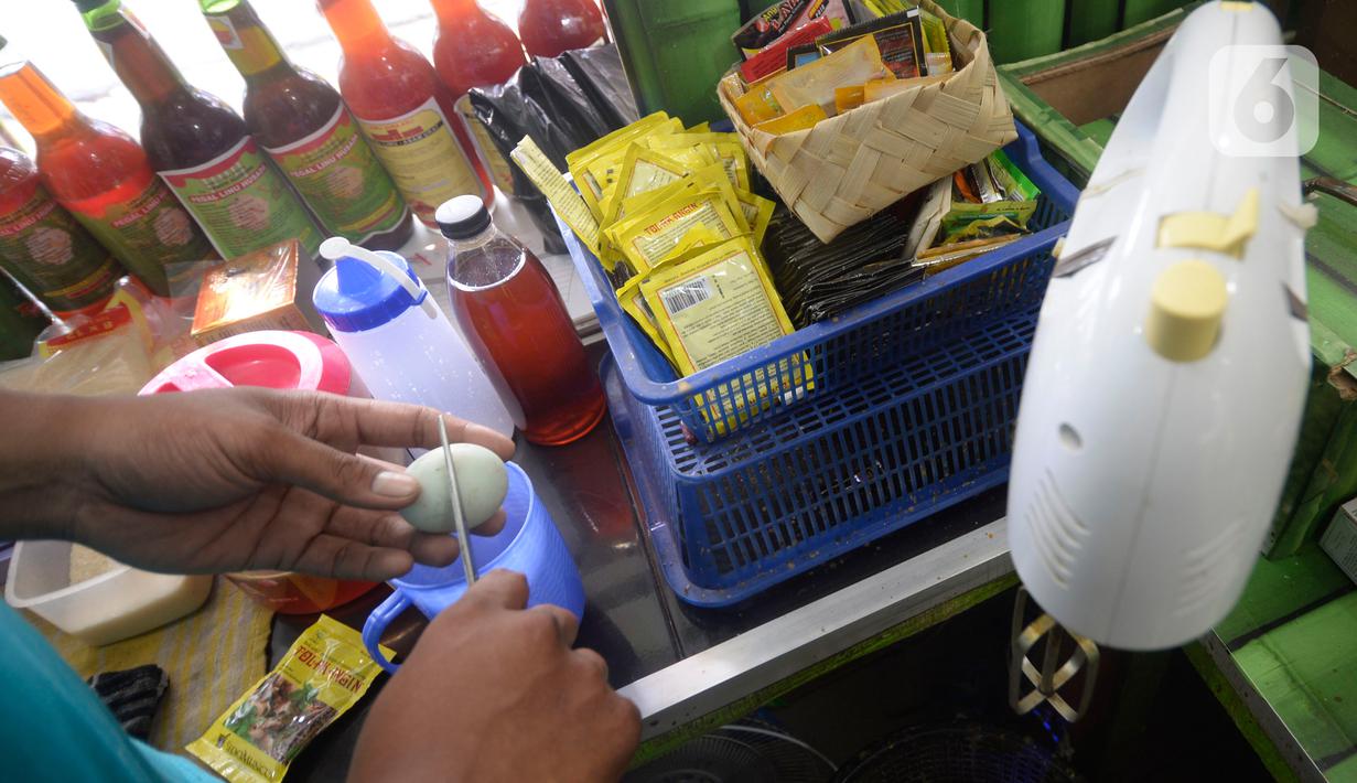 Hendri (37) menyiapkan jamu aduk untuk pembeli di kawasan Pamulang, Tangerang Selatan, Banten, Senin (28/9/2020). Menurutnya penjualan jamu aduk pada masa musim pandemi Covid 19 satu bulan ini penjualan meningkat hingga 200 persen dibandingkan bulan sebelumnya. (merdeka.com/Dwi Narwoko)