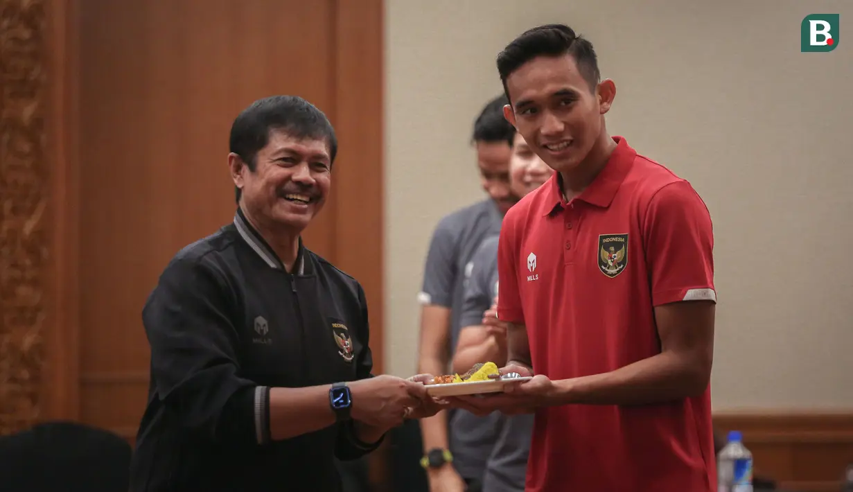 Pelatih Kepala Timnas Indonesia U-22, Indra Sjafri (kiri) memberikan potongan tumpeng terhadap Kapten Timnas Indonesia U-22, Rizky Ridho saat syukuran terkait sanksi ringan FIFA terhadap Indonesia dan kesempatan Timnas Indonesia U-22 tampil di SEA Games 2023 di Ruang Semeru, Hotel Sultan, Jakarta. (Bola.com/Bagaskara Lazuardi)