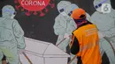 Petugas PPSU Kelurahan Bukit Duri menyelesaikan mural bertema Covid-19 di Jakarta, Selasa (11/8/2020). Mural tersebut untuk mengingatkan warga agar selalu waspada dengan Covid-19 dan mencegahnya dengan 3M (Memakai Masker, Menjaga Jarak dan Mencuci Tangan). (Liputan6.com/Faizal Fanani)